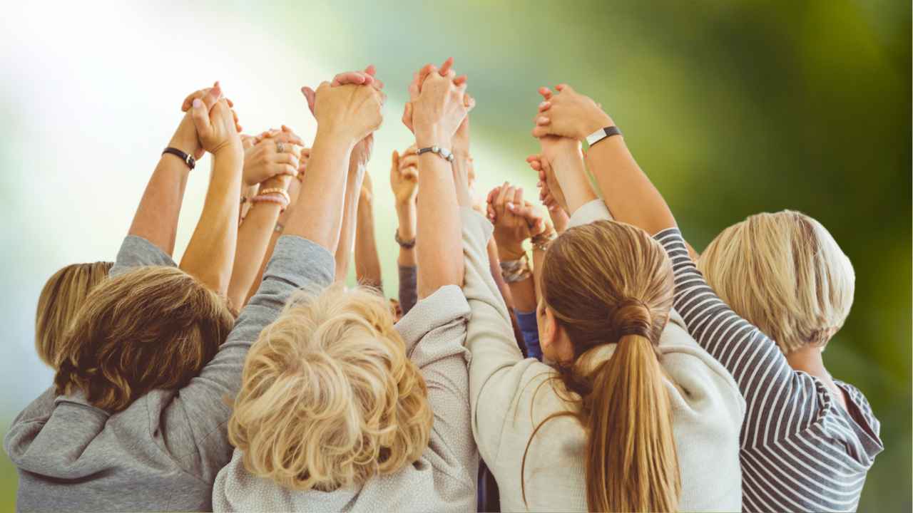Vrouwen-godinnenkracht Vrouwen staan in sisterhood verbonden,met handen verenigt in de lucht.